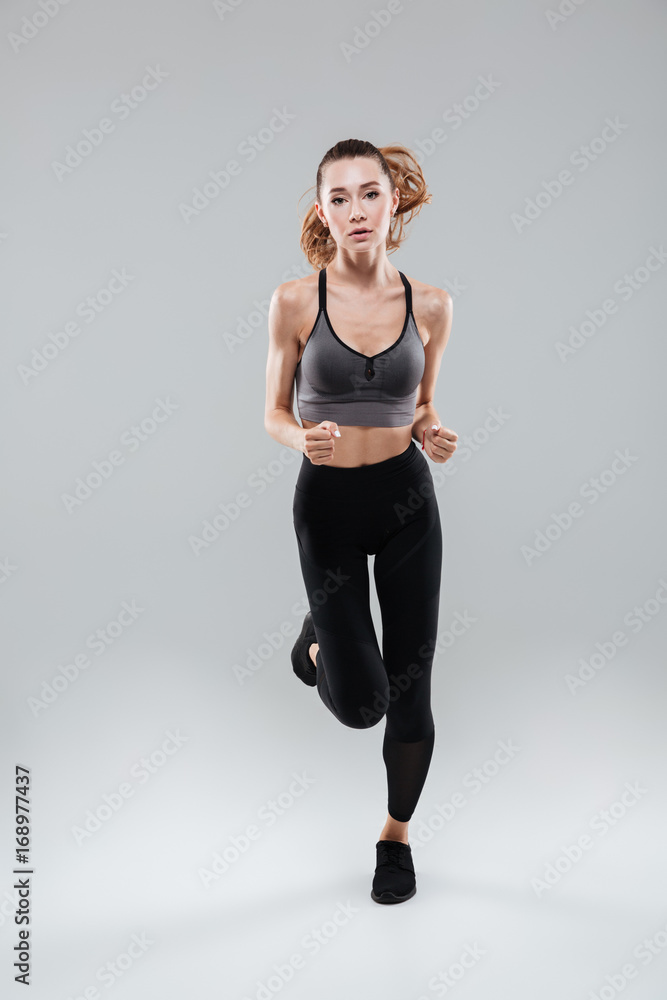 Full length portrait of a young woman in sportswear running Full length portrait of a young woman in sportswear running