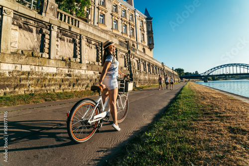 pretty woman ride bicycle on embankment of Wisla river