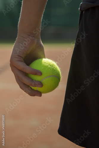 mano che tiene una pallina da tennis