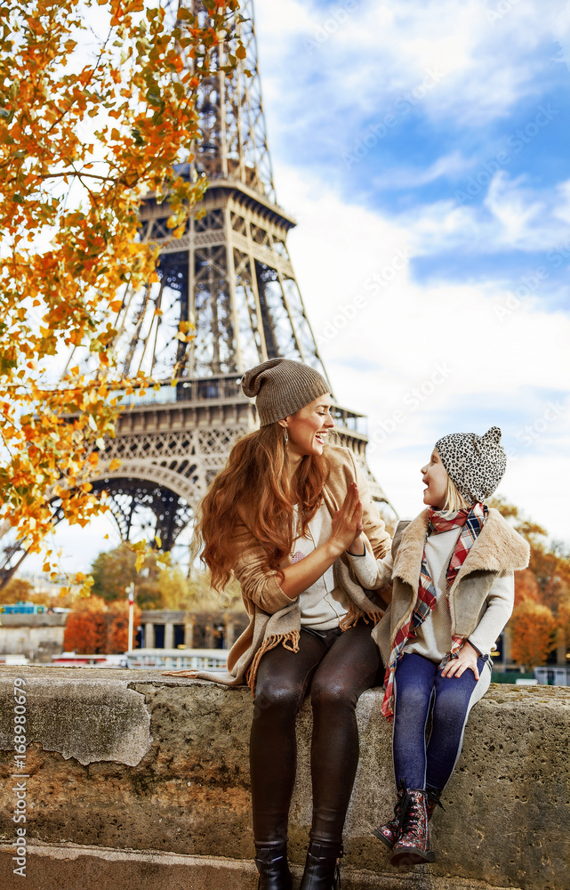 mother and child travelers playing on embankment in Paris