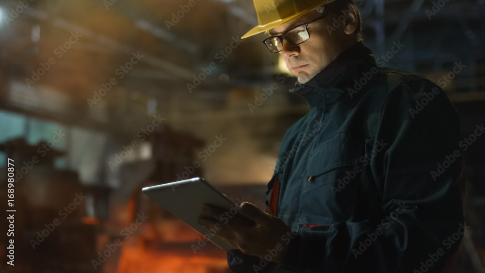 Engineer in Glasses using Tablet PC in Foundry. Industrial Environment.