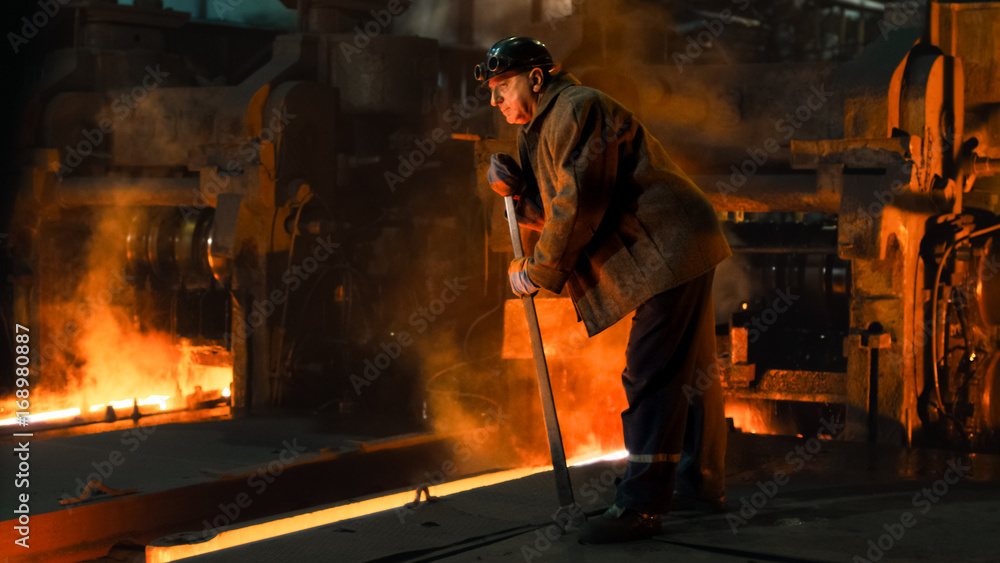 Heavy Industry Worker Doing Quality Control in Foundry. Rough Industrial Environment. Wide Shot. Heavy Industry Worker Doing Quality Control in Foundry. Rough Industrial Environment. Wide Shot.