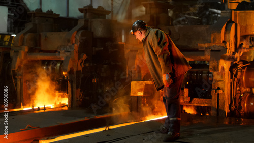 Heavy Industry Worker Working Hard in Foundry. Rough Industrial Environment. Wide Shot.