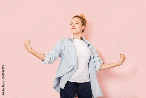 Young self-confident woman on a pink background