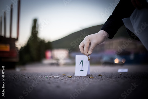The crime scene, murder, investigation, sleeves shots serve as evidence, the investigation is done, the expert takes the capsule forceps and placed in the bag