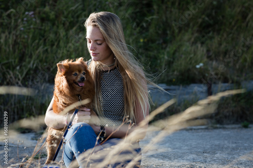 Young Female cuddling her pet dog in countryside