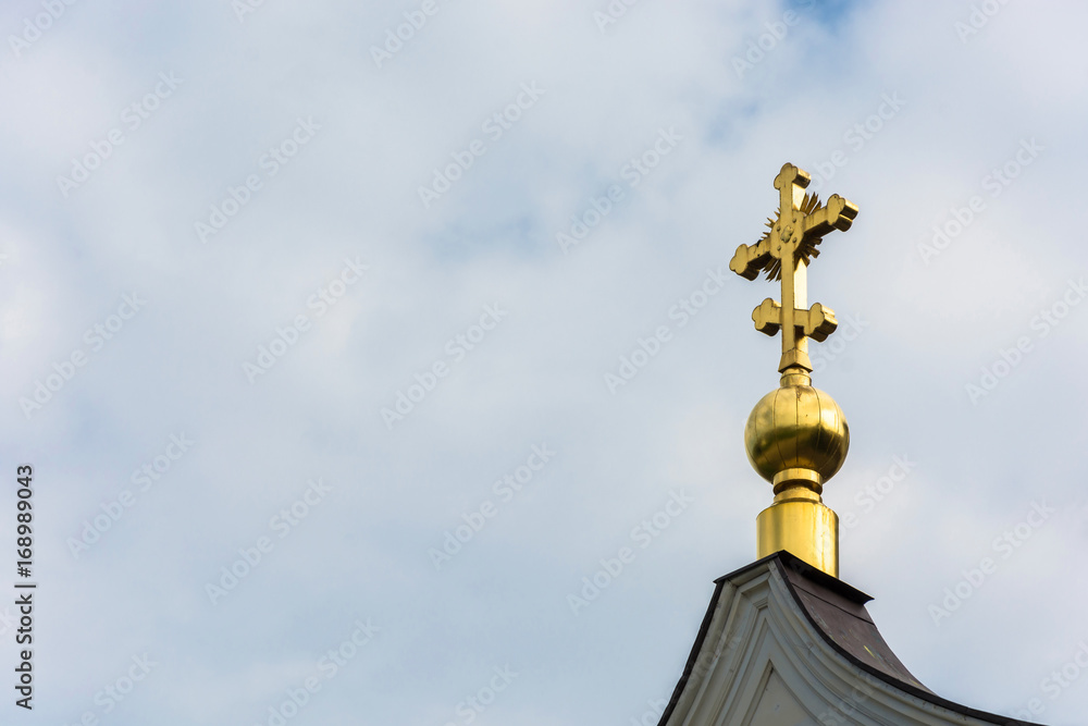Golden cross on a small Golden dome.