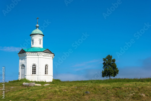 A small chapel on the background of blue sky.