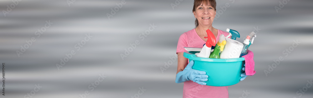 Housewife holding a bucket with cleaning equipment Housewife holding a bucket with cleaning equipment