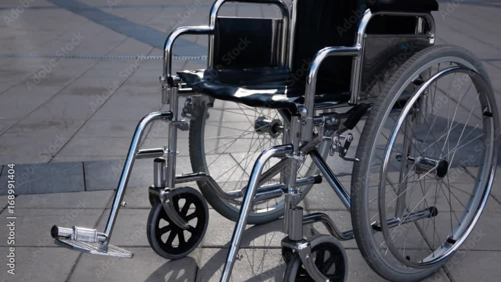Disabled wheelchair rolling near modern business district. steadicam shot. Imminent illness concept. Disease. Slow motion, Disabled wheelchair rolling near modern business district. steadicam shot. Imminent illness concept. Disease. Slow motion,