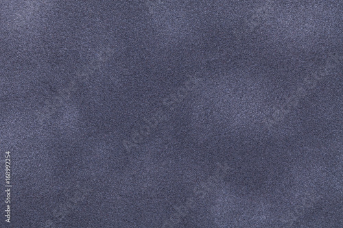 Background of dark gray and blue suede fabric closeup. Velvet matt texture of nubuck textile