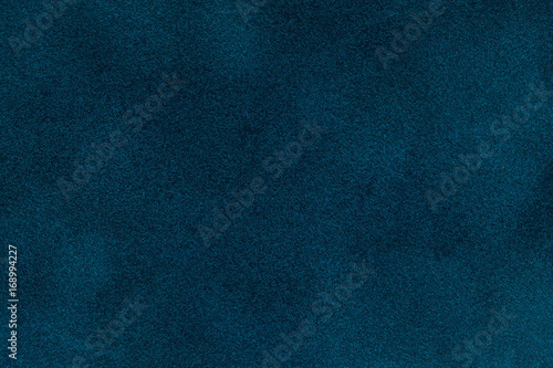 Background of dark blue suede fabric closeup. Velvet matt texture of navy blue nubuck textile photo