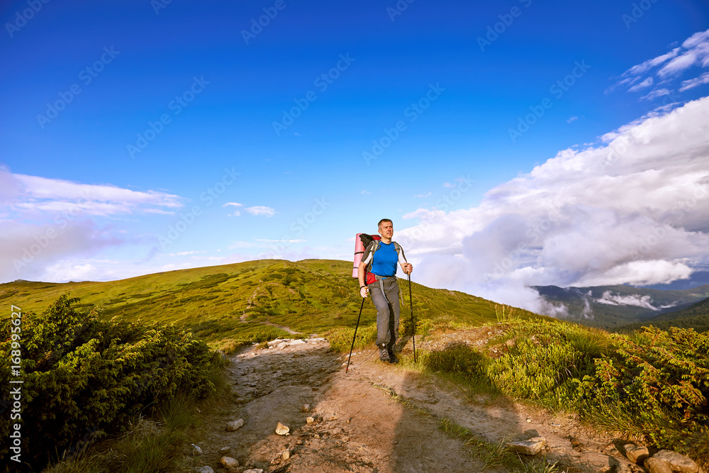 Hiking in the mountains in the summer with a backpack.