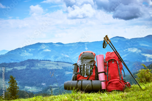 Backpacks in the mountains overlooking the mountains on the green grass. photo