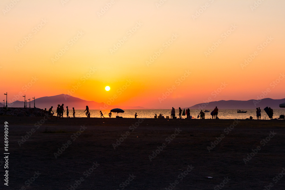 Silhouetted shot of young people are having fun on beach and playing football Silhouetted shot of young people are having fun on beach and playing football