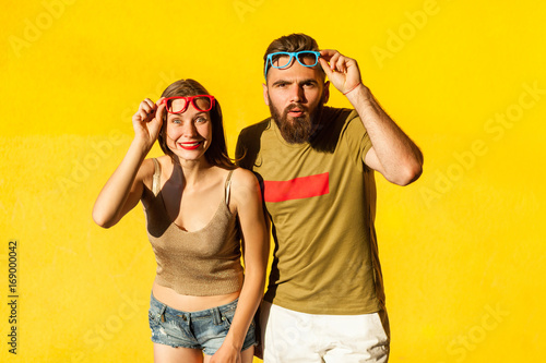 Funny couple in casual style clothes and color glasses