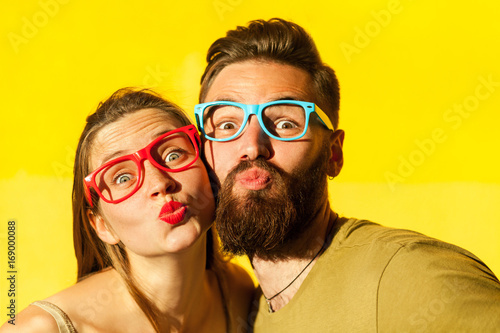 Freckled woman, and bearded man send air kissing at camera