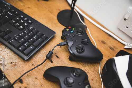 Gamepads with keybaord on a wooden table 