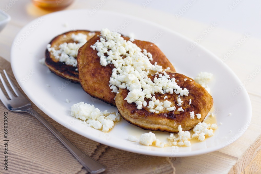 Homemade gluten free pancakes with cottage cheese and honey served on oval plate
