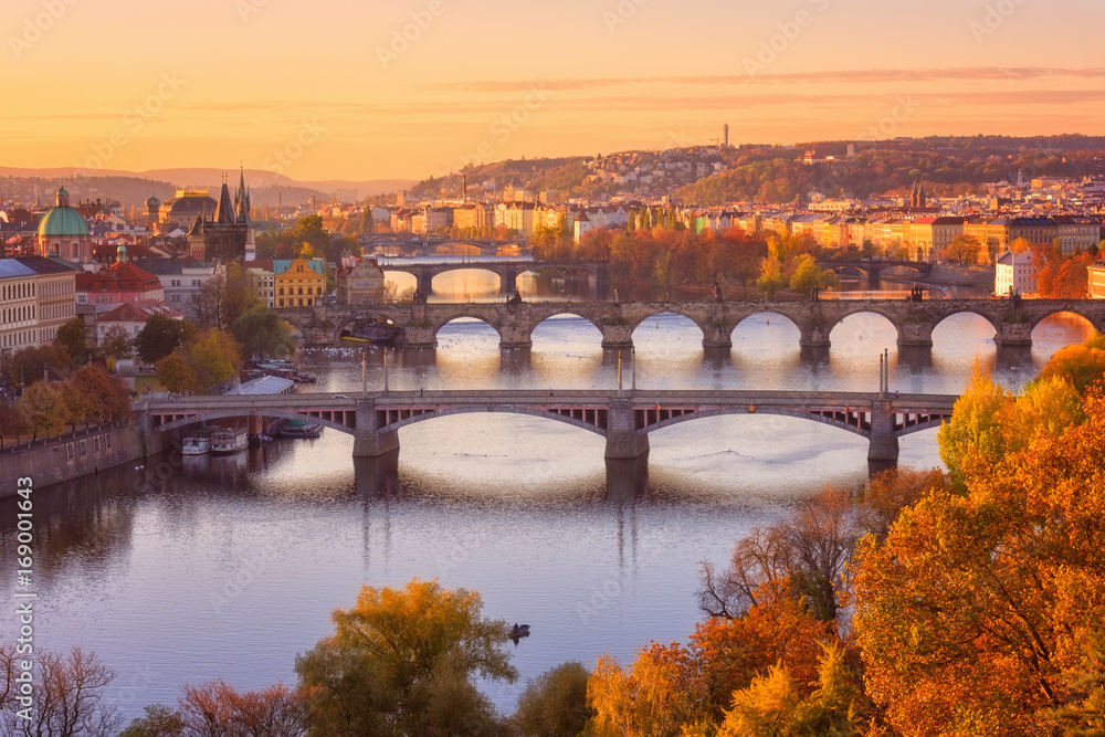 Autumn in Prague, view to the historical bridges, old town and Vltava river from popular view point in the Letna park (Letenske sady), beautiful landscape in soft yellow morning light, Czech Republic