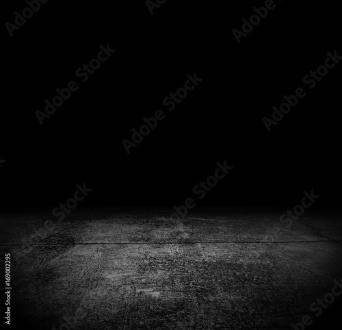 An empty grunge cement floor in the dark for horror or scary background