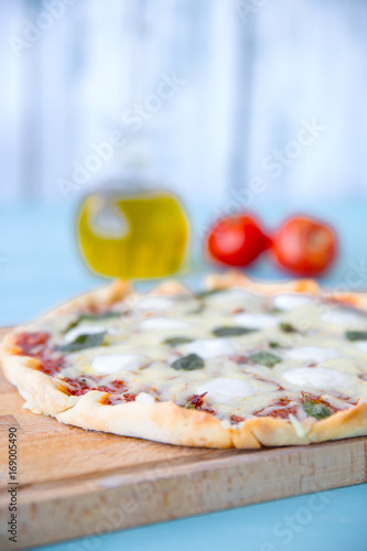 pizza with olive oil and tomatoes on a blue background