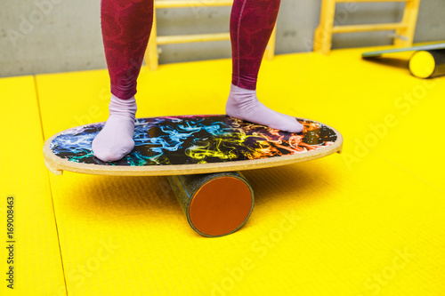 Amateur athlete exercising on a board for balance at indoor fitness gym, modern sport concept photo