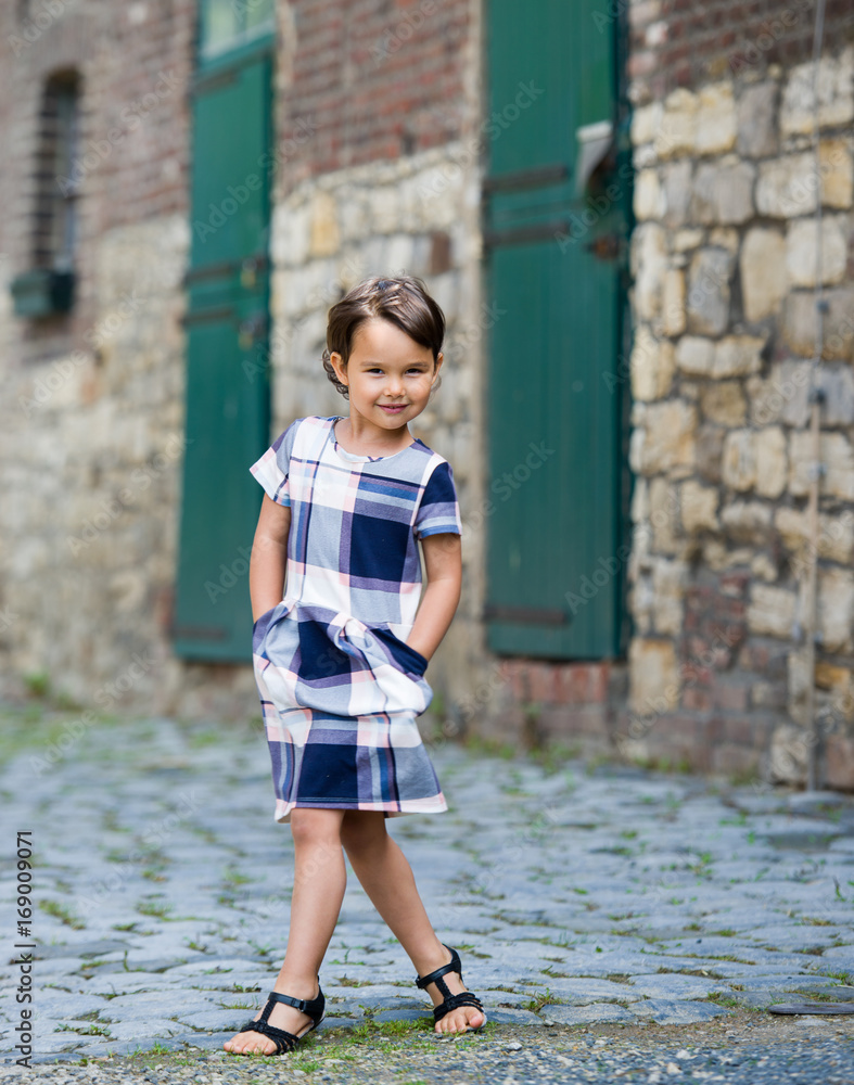 Little girl in an urban setting smiles at the camera. Little girl in an urban setting smiles at the camera.