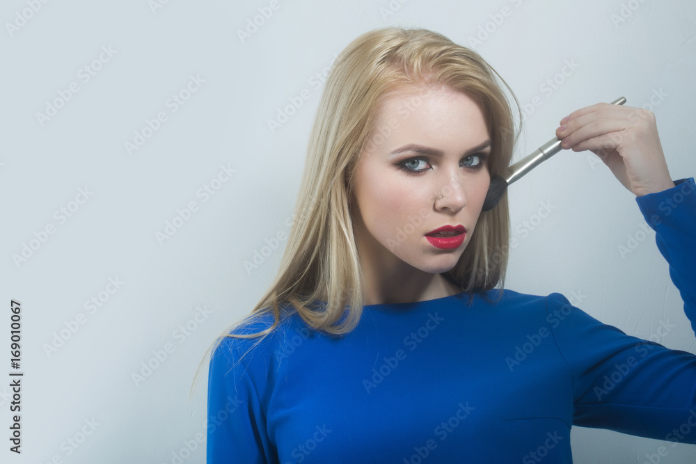 Obraz premium Woman applying powder on face skin with makeup brush