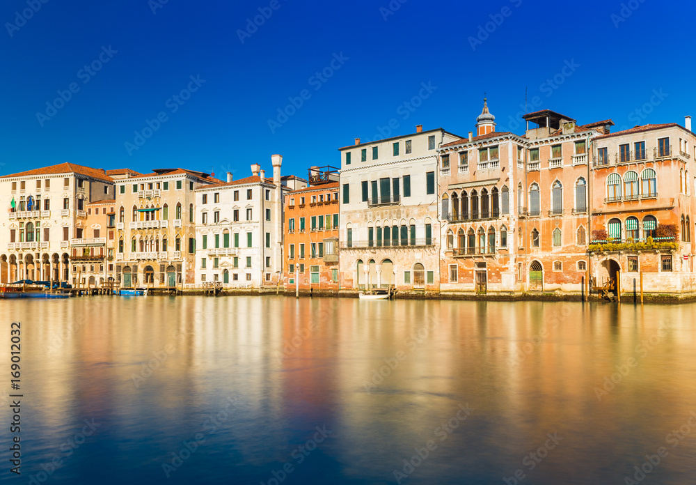 Venice, Italy: Old houses in the traditional Venetian architecture style reflected in the Grand Canal of Venice. Long exposure photo