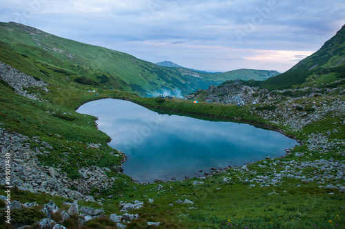 Panoramic photo of a mountain lake in a mountainous rocky valley. Serene lake Berbeneskul, Carpathians, Ukraine.