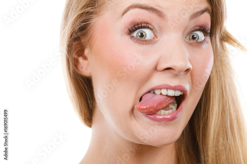 Funny blonde woman sitcking tongue out