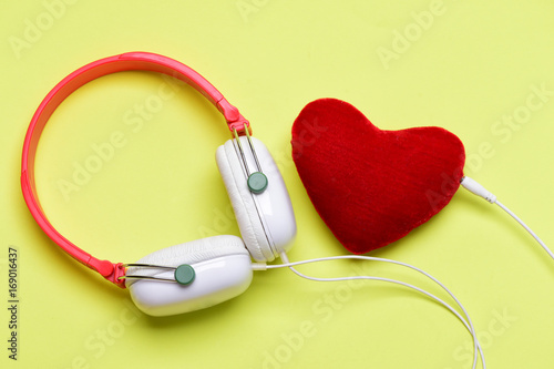 Modern and stylish earphones isolated on light yellow background