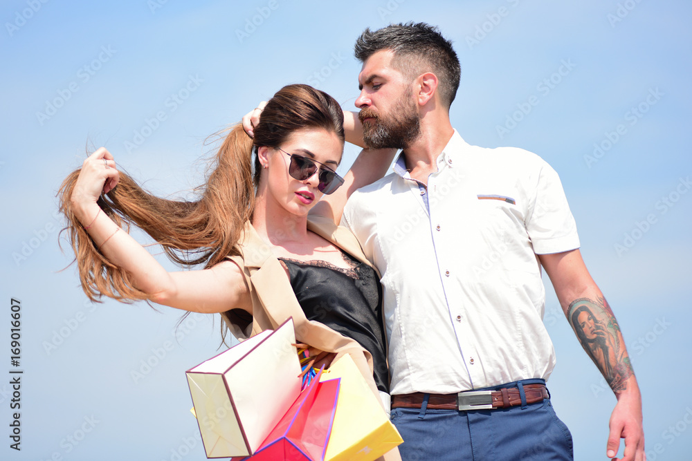 Man with beard and long haired woman hold shopping bags
