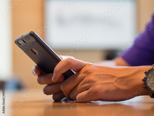 Man hand holding and watching mobile phone