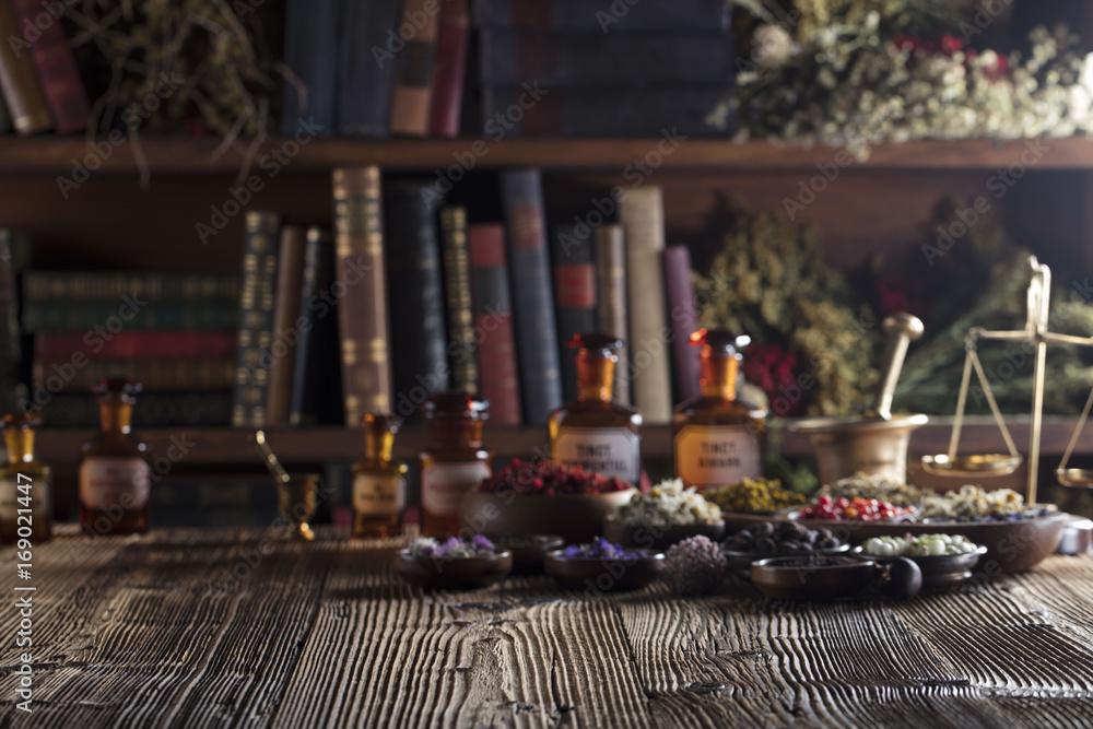 Natural medicine. Shallow depth of focus. Wooden table. Herbs, berries and flowers in bowls. Beautiful bokeh.