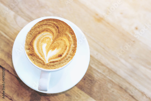 Hot art coffee cappuccino in a cup on wooden table background with copy space