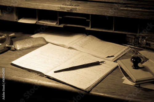 Vecchi documenti con penna in uno scrittoio di legno - stile seppia photo