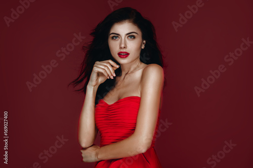 Wallpaper Mural Beauty Brunette Woman with Perfect Makeup in red dress. Beautiful Professional Holiday Make up. Beauty Girl  Face  studio portrait isolated on red background Torontodigital.ca