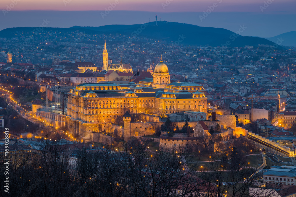 Budapest, Hungary - The Historic Royal Palace aka Buda Castle with Matthias Church and the Buda Hills at background at blue hour