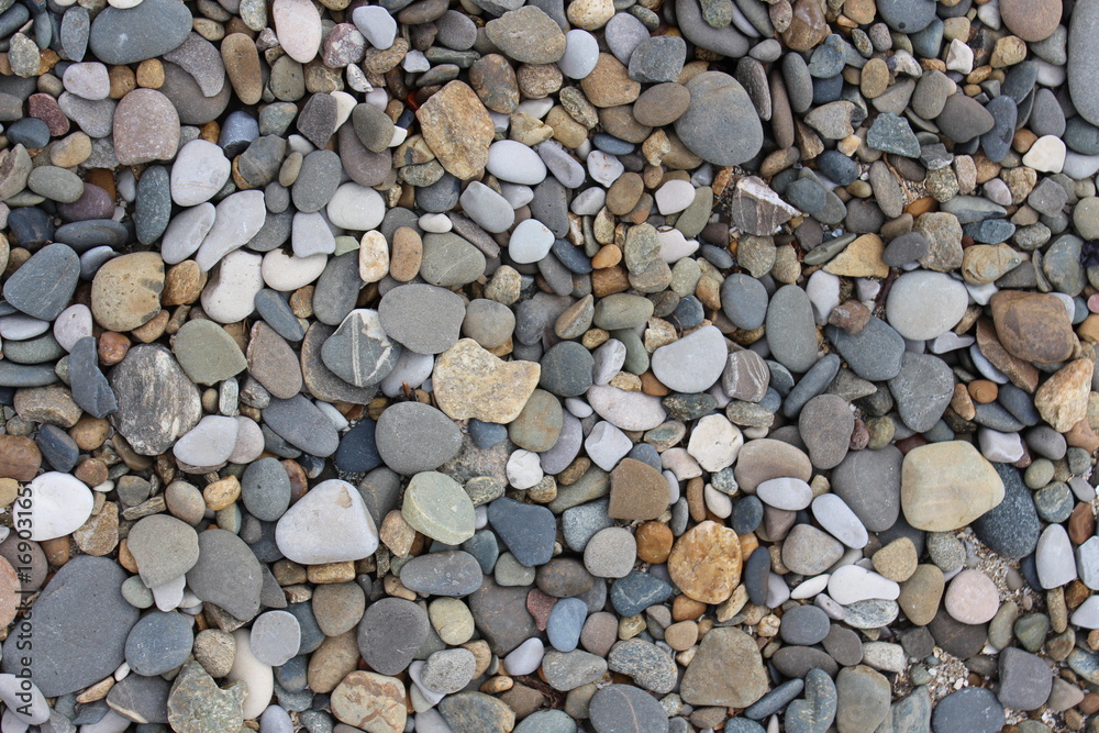 Multi-colored pebbles are on the sea beach Multi-colored pebbles are on the sea beach