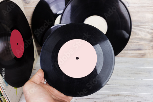 collection of old vinyl record lp's with sleeves on a wooden background. Browsing through vinyl records collection. Music background. Copy space.