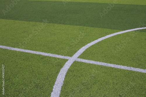 Photo of a green synthetic grass sports field with white line shot from above © Fotoglee