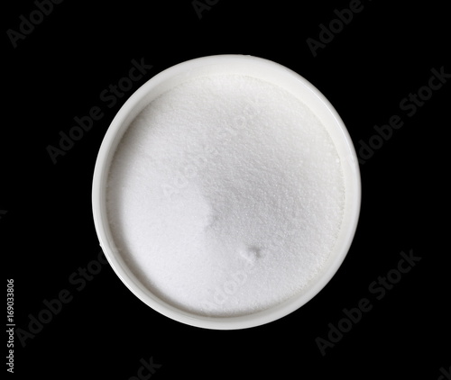 Salt pile in bowl isolated on black background