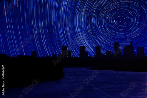 Obraz na płótnie Photomontage panorama of Warsaw with flowing river and stars track w salonie