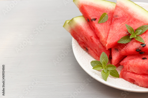 Slices of watermelon on a plate on a gray background. Selective focus Copy space