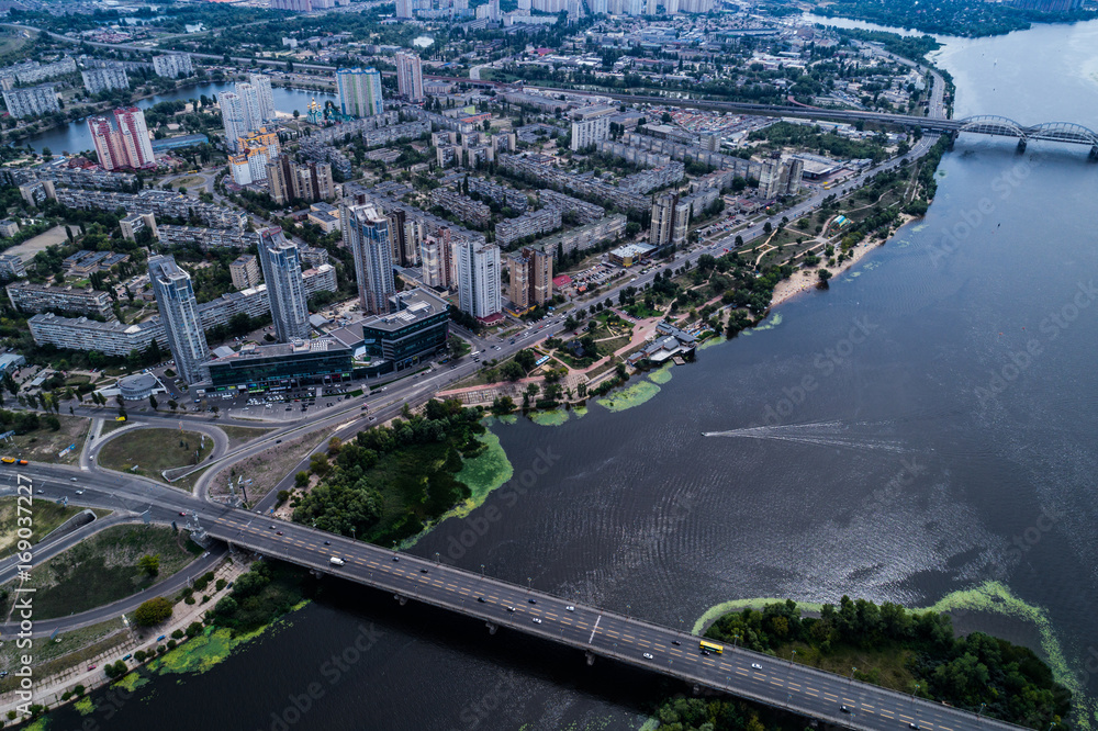 Residential district in a large metropolis with road junctions and houses near Dnepr river in Kiev, Ukraine. Aerial view. From above.