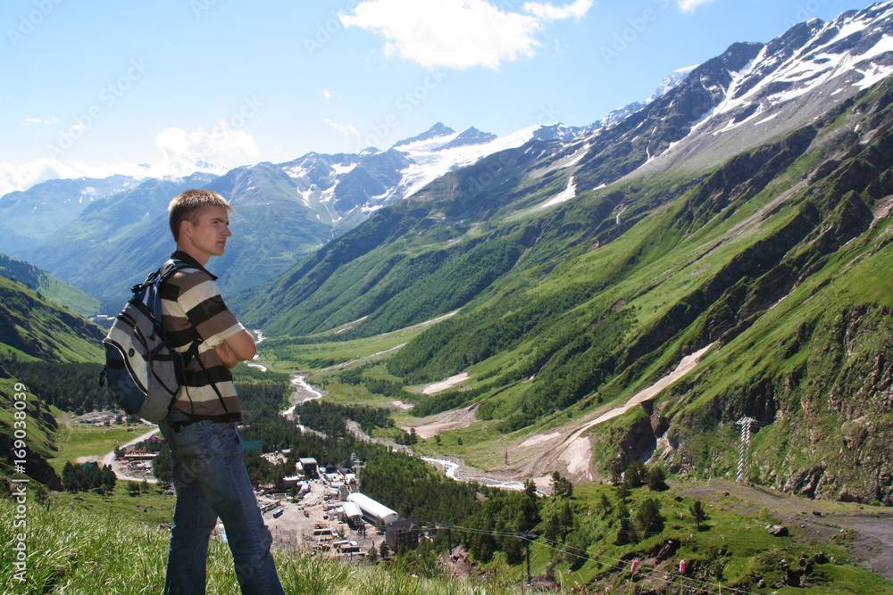 Man with backpack in mountains looking forward. 