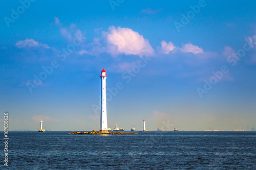 Lighthouses at sea. White lighthouse. The lighthouse on the horizon. Navigation for ships. © Grispb