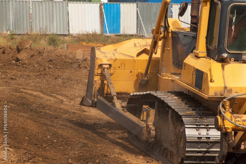 Excavator working on a construction site. Yellow Construction bulldozer at Work. Construction of a new road.